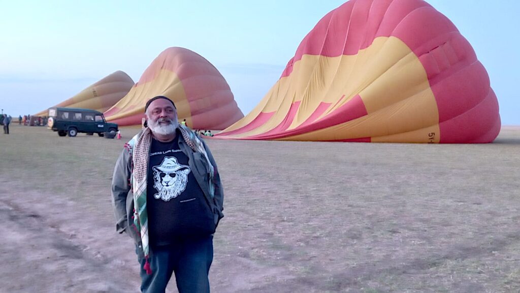 Arun standing in front of 3 half filled Hot air balloons